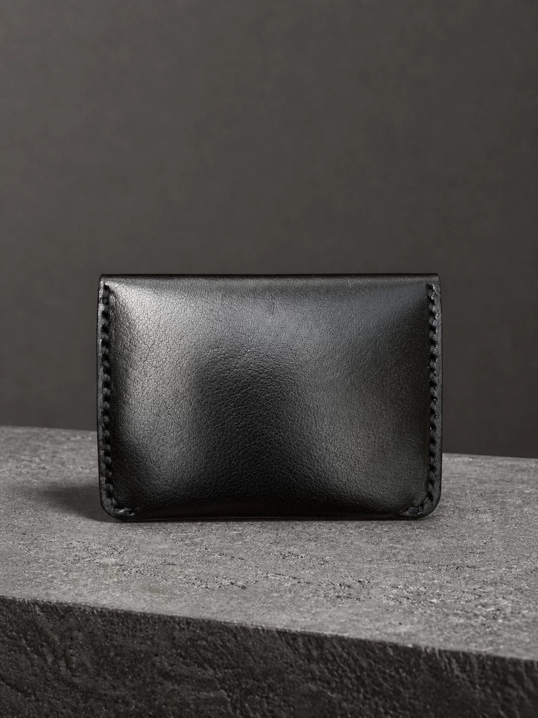 Rox & Oak Terra premium black leather card holder wallet front view on dark textured background
