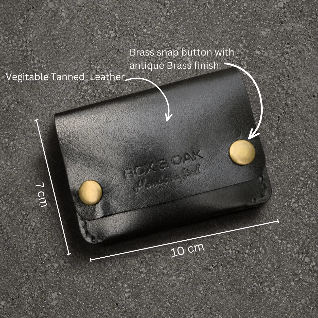 Rox & Oak Terra vegetable tanned black leather wallet close-up with antique brass hardware on textured background