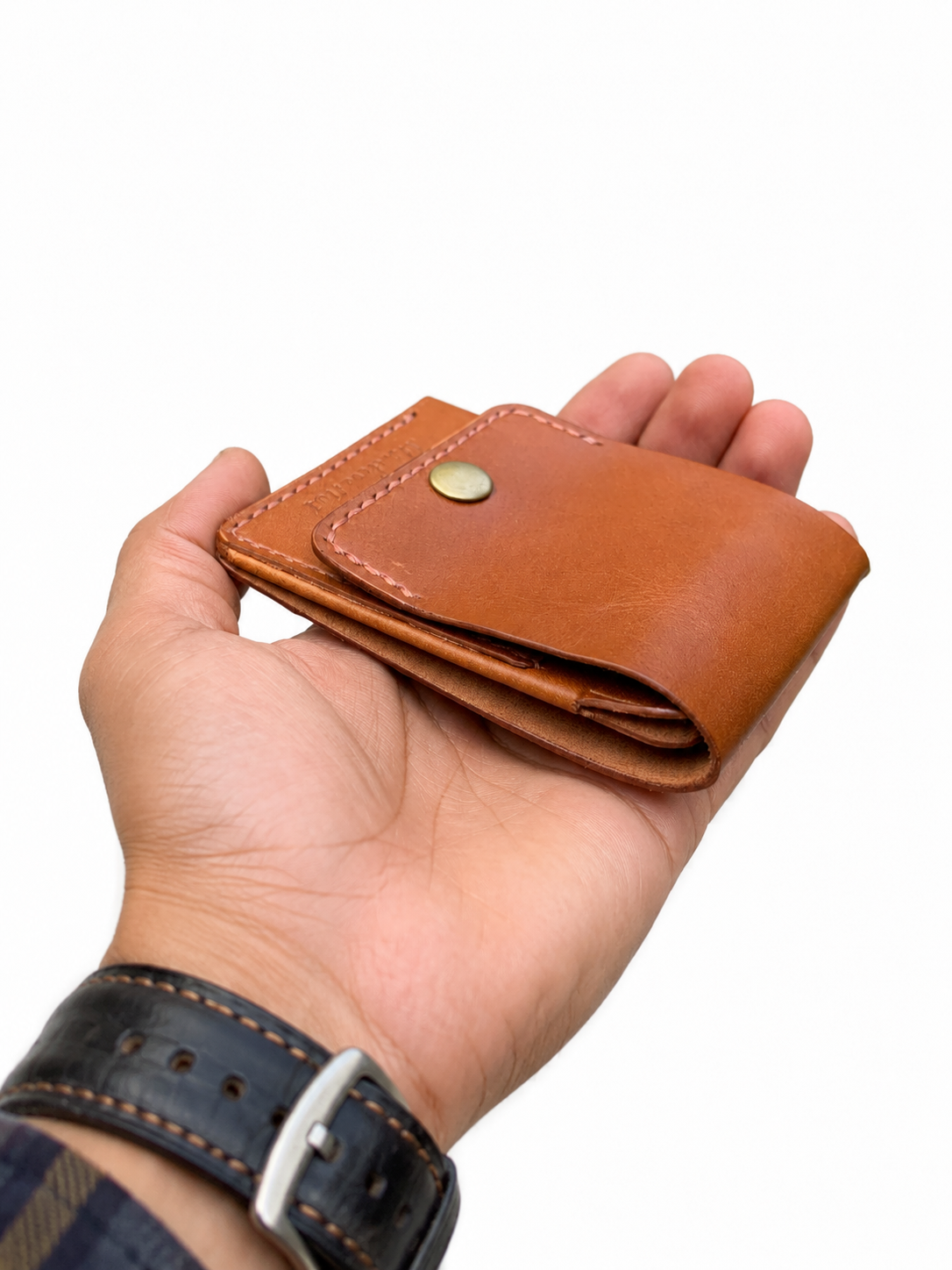 Hand holding Rox & Oak chestnut brown vertical flip slim leather wallet with snap button closure.